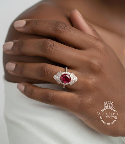 A close-up of a person's hand wearing a ring with a large, vibrant red gemstone.