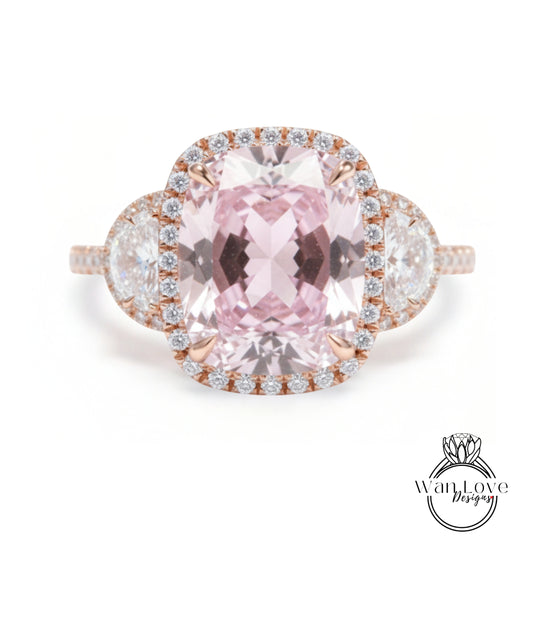 A large, pink gemstone ring with a halo of smaller diamonds around the center stone.