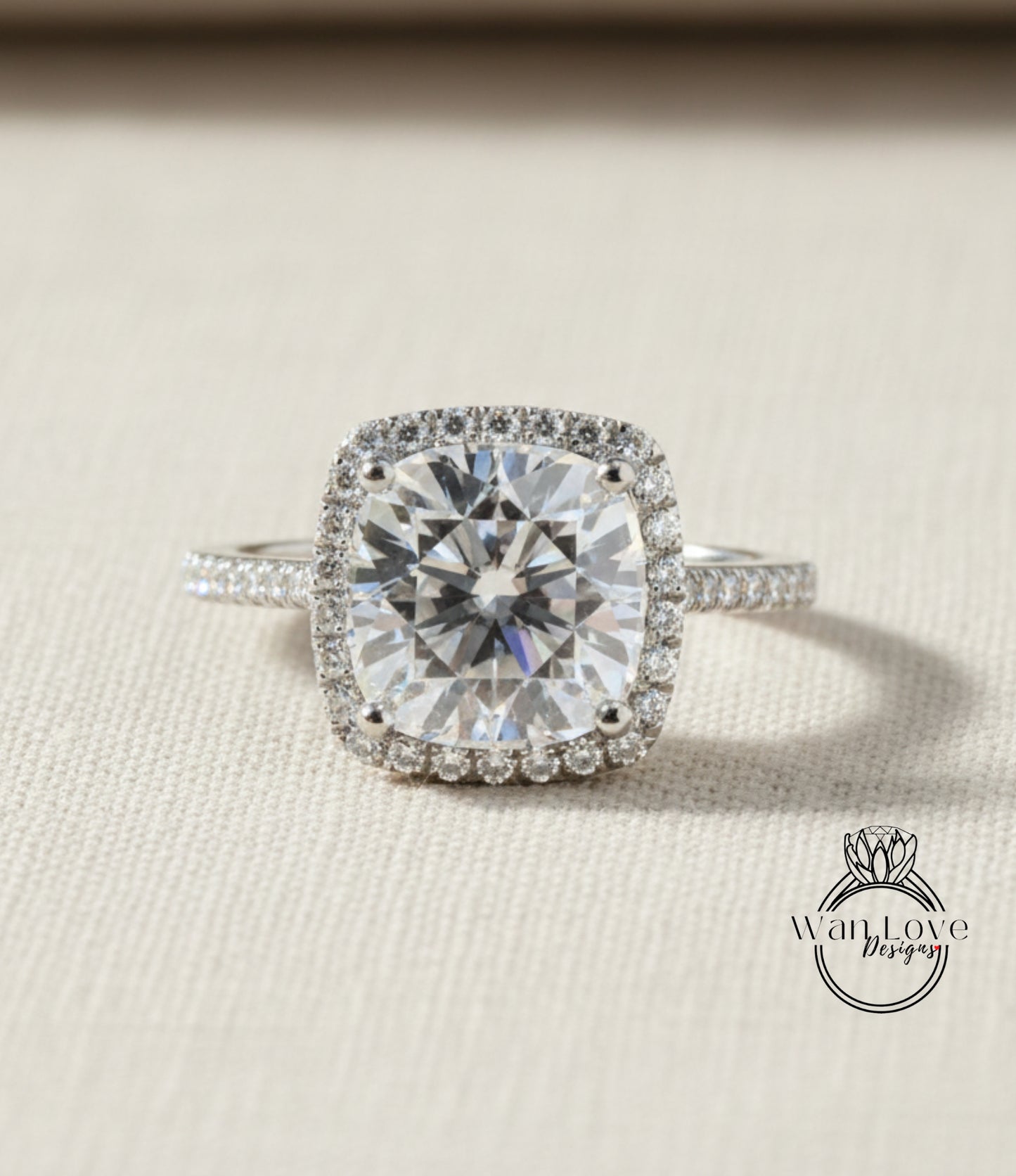 A large, brilliant-cut diamond engagement ring with a halo of smaller diamonds around the center stone, set in a silver band.