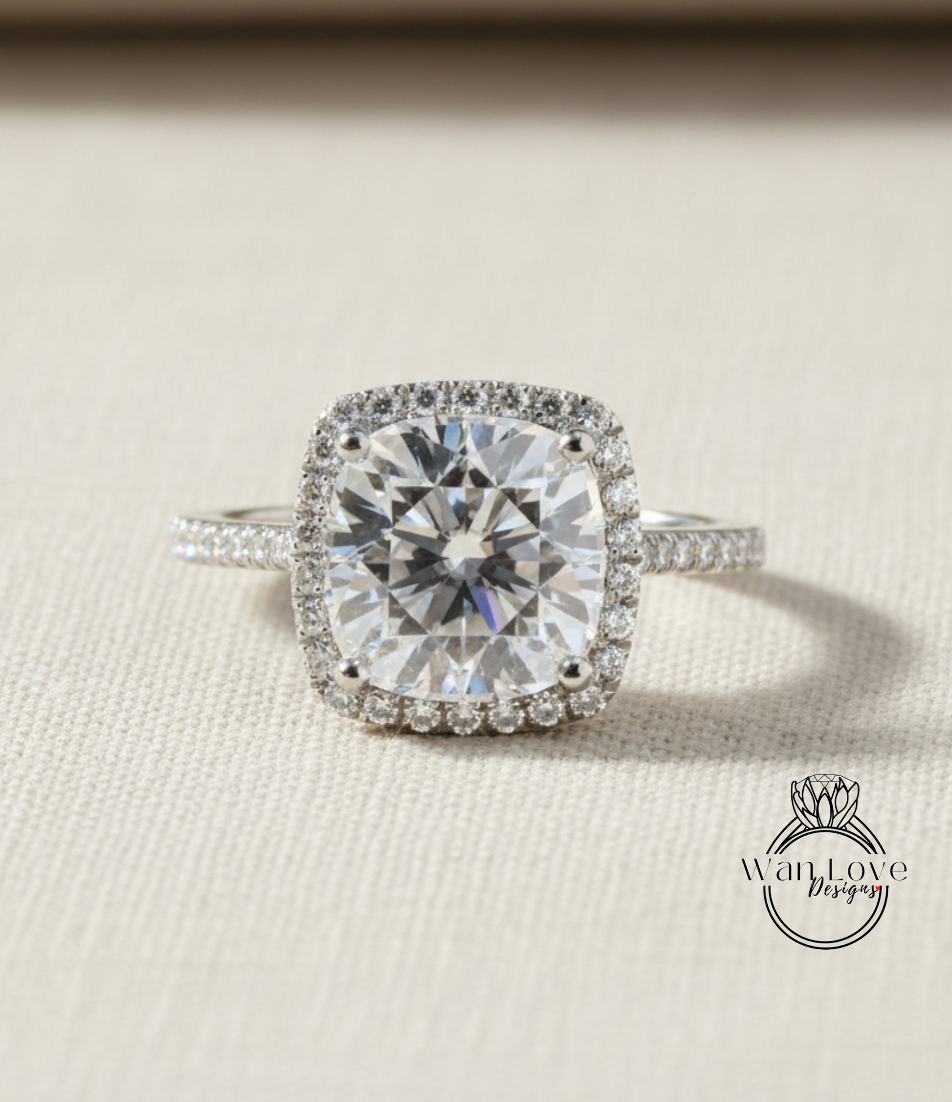 A large, brilliant-cut diamond engagement ring with a halo of smaller diamonds around the center stone, set in a silver band.