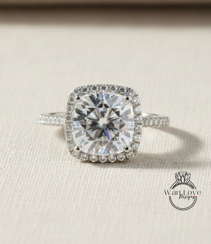 A large, brilliant-cut diamond engagement ring with a halo of smaller diamonds around the center stone, set in a silver band.