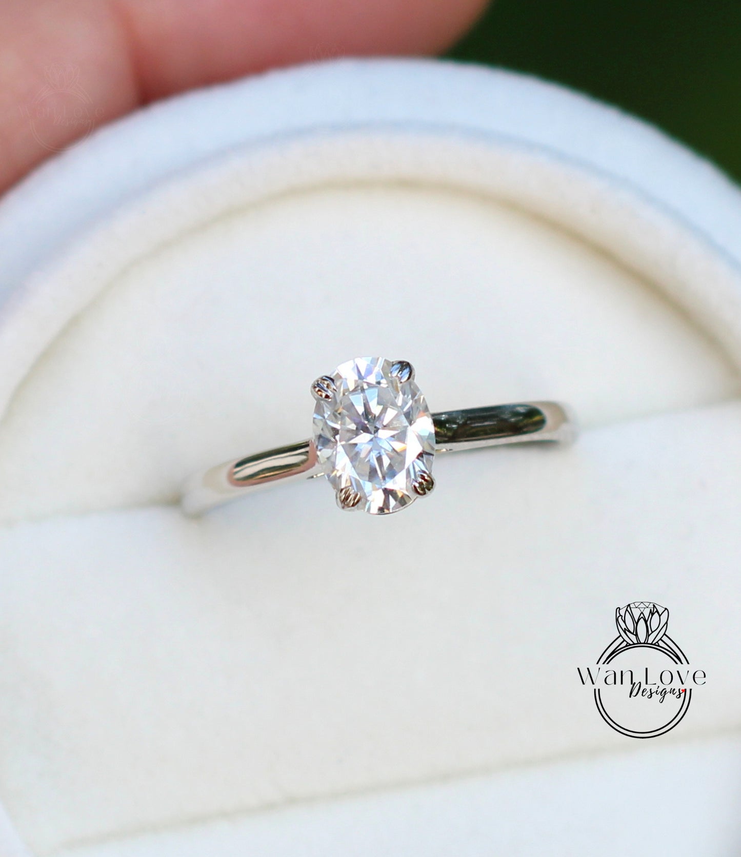 A close-up view of a diamond engagement ring, showcasing a large oval-shaped diamond set in a silver band.