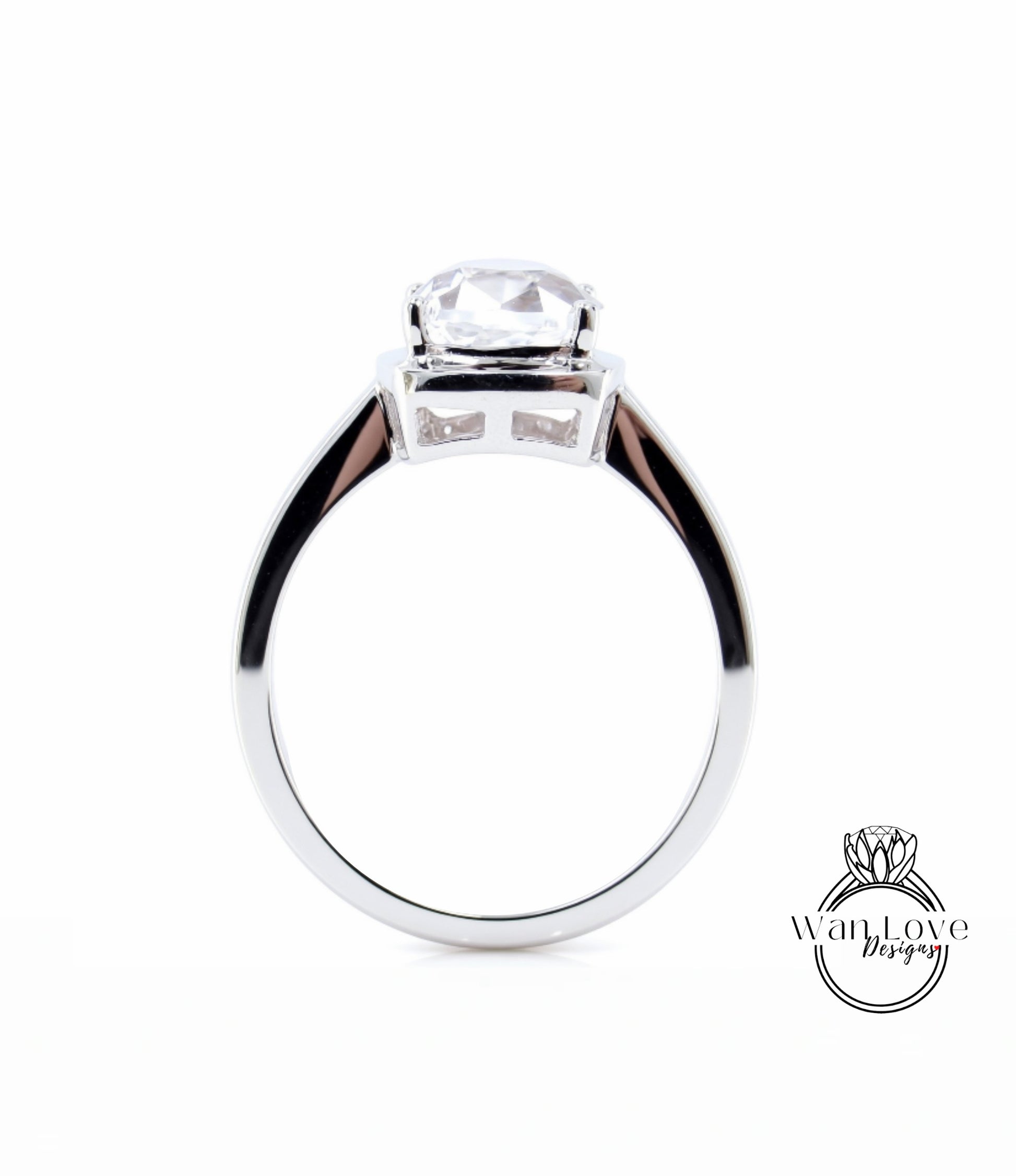 A silver engagement ring with a large, clear gemstone set in the center.