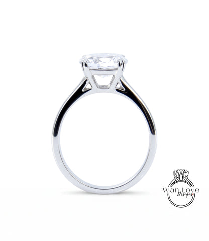 A silver engagement ring with a large, clear gemstone set in the center of the band.