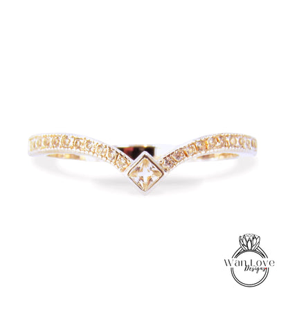 A gold ring with a diamond-encrusted band and a square-shaped gemstone in the center.