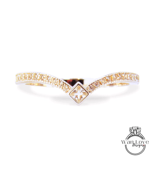 A gold ring with a diamond-encrusted band and a square-shaped gemstone in the center.