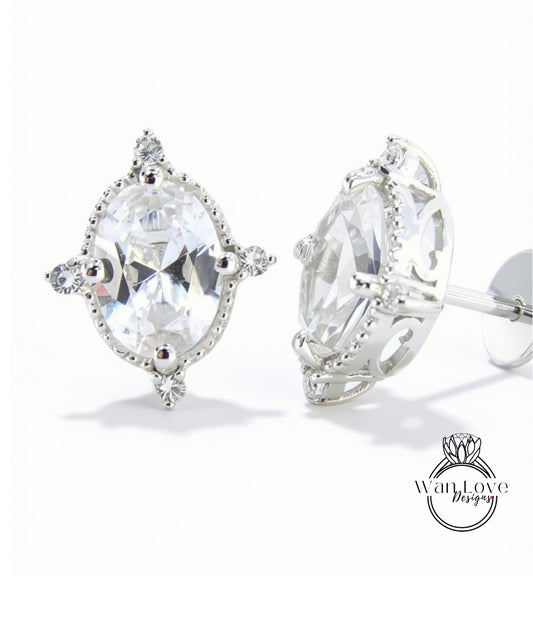 A pair of elegant earrings with a large, clear gemstone set in a decorative metal frame.