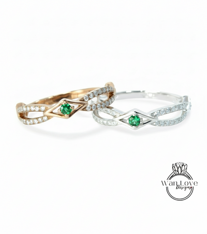 two rings with a diamond-encrusted design and a green gemstone, possibly a diamond or emerald, set in the center.