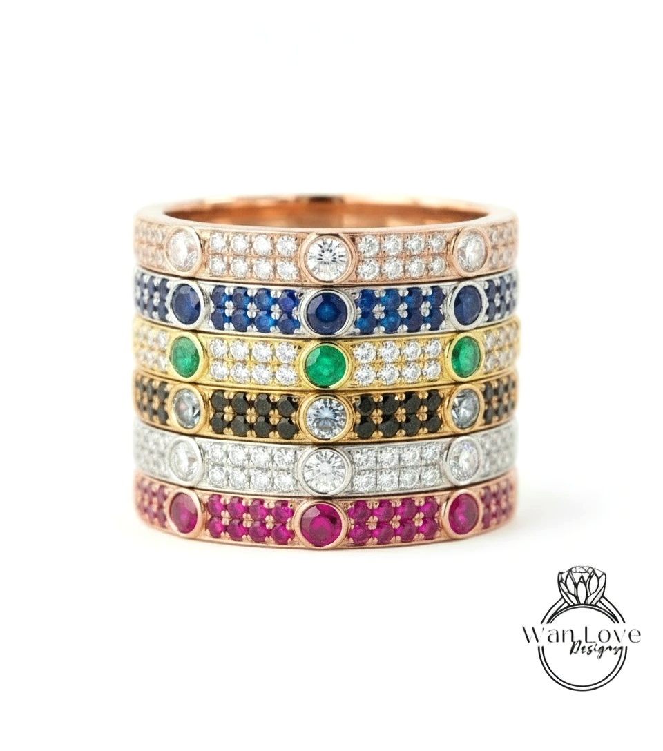 A stack of rings with various colored gemstones and diamonds set in the center.