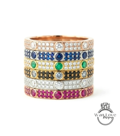 A stack of rings with various colored gemstones and diamonds set in the center.