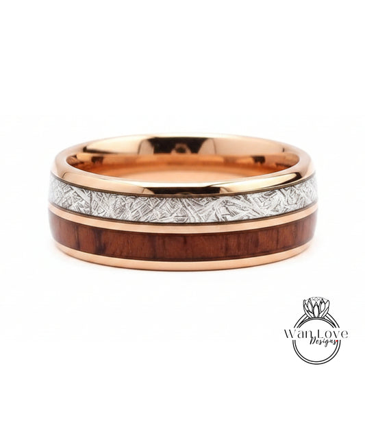 A gold-toned ring with a wooden band and a metallic band with a patterned design.