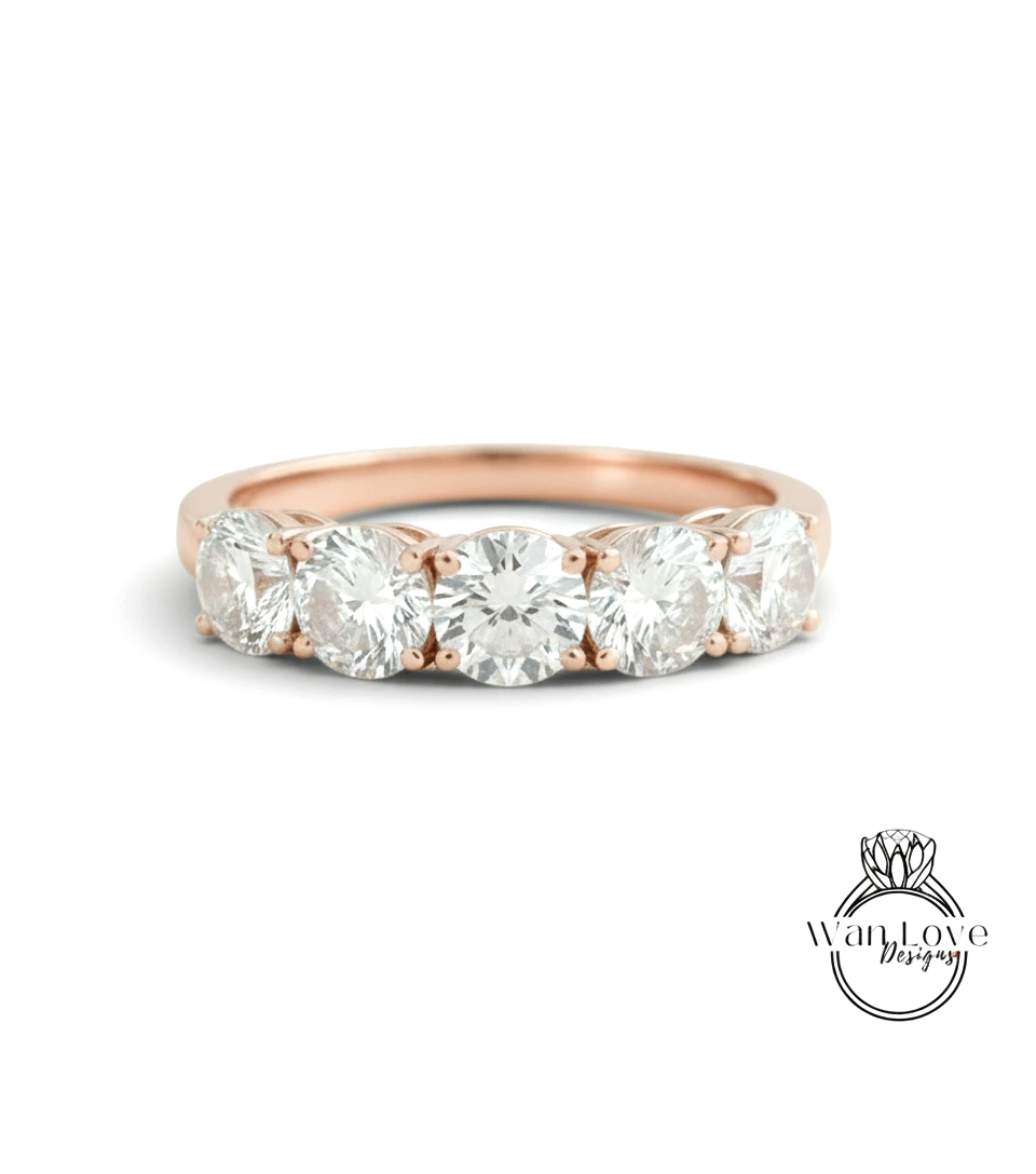 A rose gold ring with a row of five round diamonds set in the band.