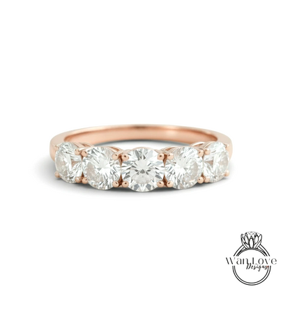 A rose gold ring with a row of five round diamonds set in the band.