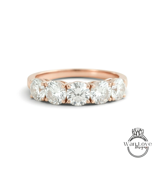 A rose gold ring with a row of five round diamonds set in the band.