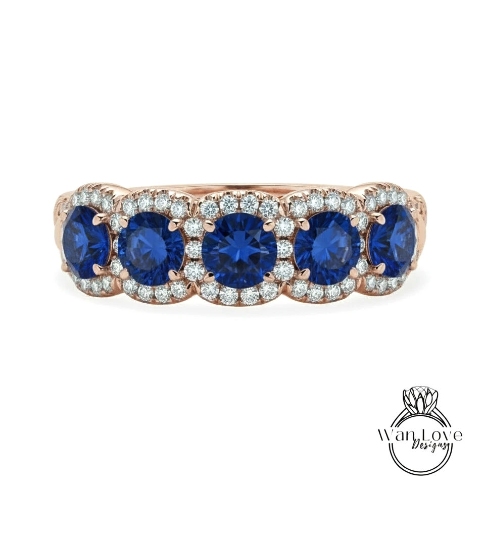 A rose gold ring with a row of blue sapphires and diamonds set in the center.