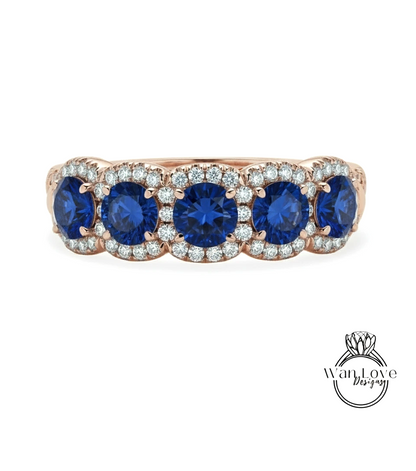 A rose gold ring with a row of blue sapphires and diamonds set in the center.