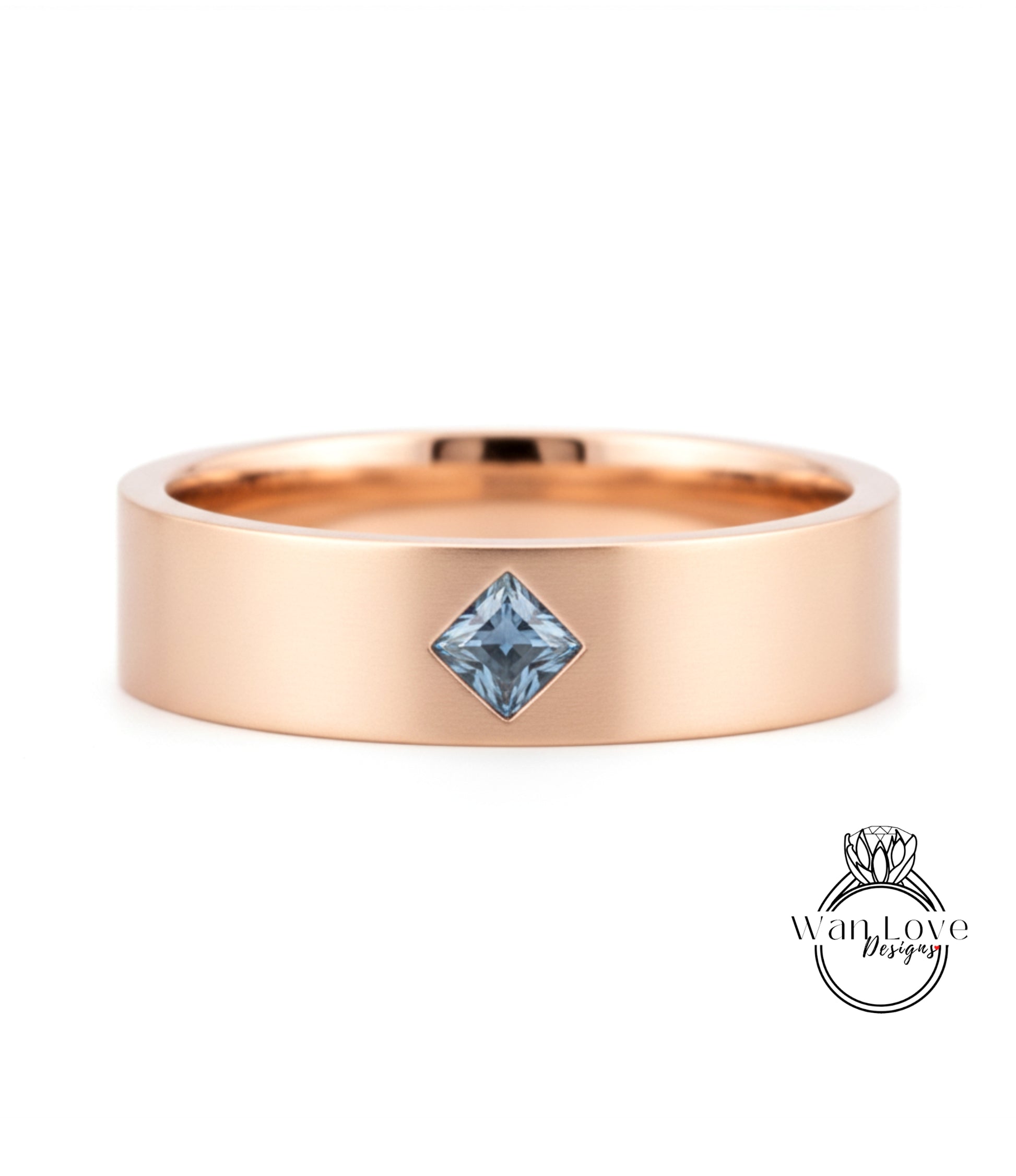 A gold-colored ring with a blue gemstone, possibly a diamond, set in the center.