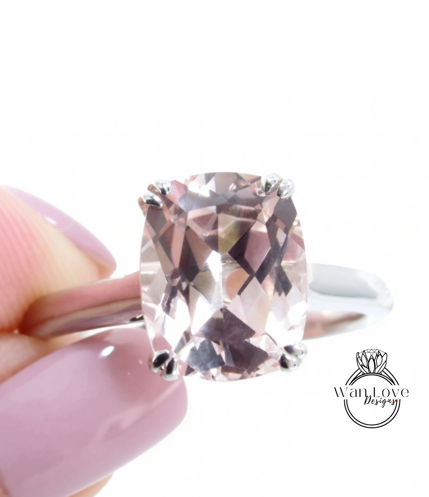 A close-up image of a person's hand holding a ring with a large, clear gemstone, likely a diamond, on the ring finger.