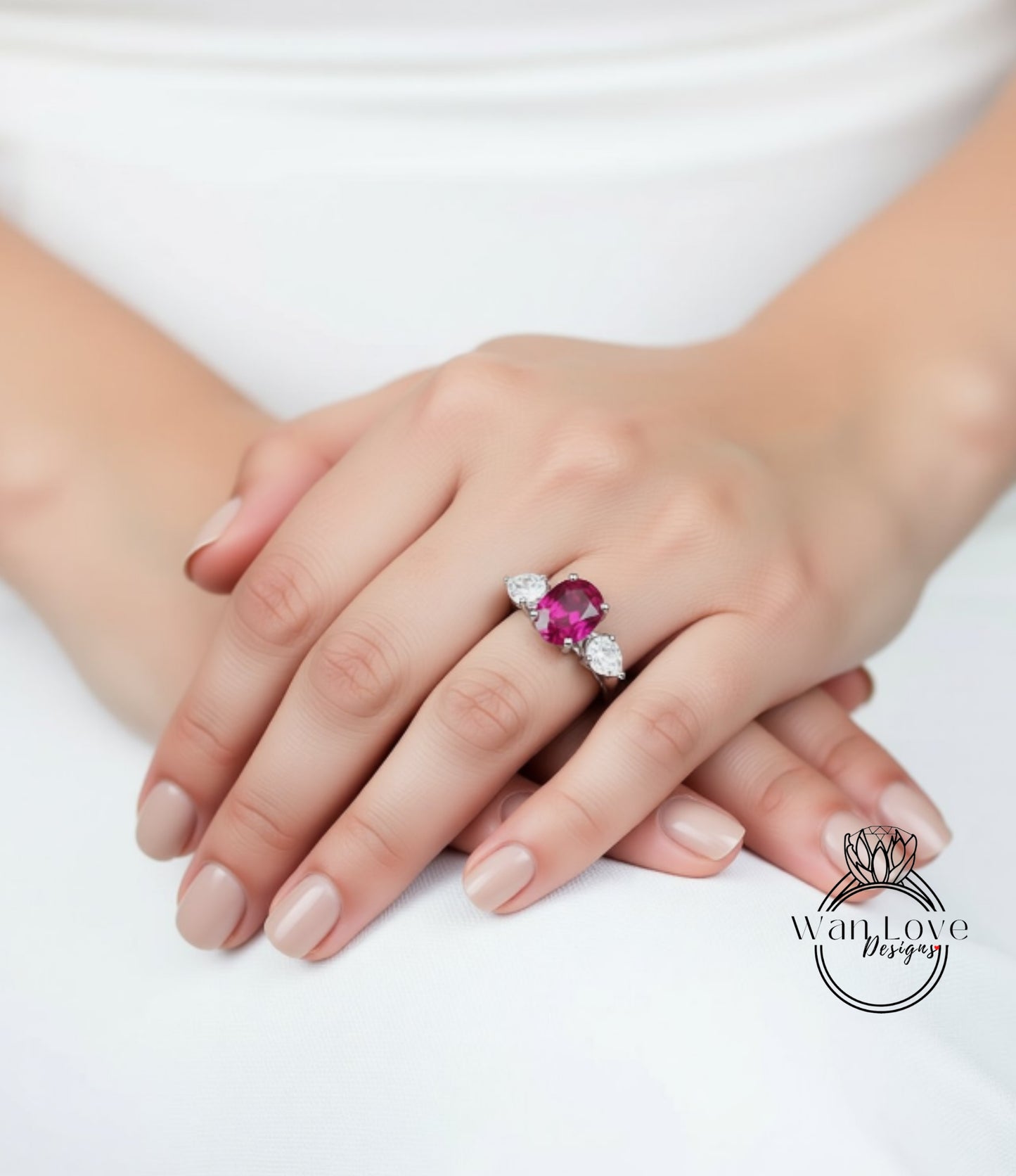 A close-up of a person's hands wearing a ring with a large pink gemstone.