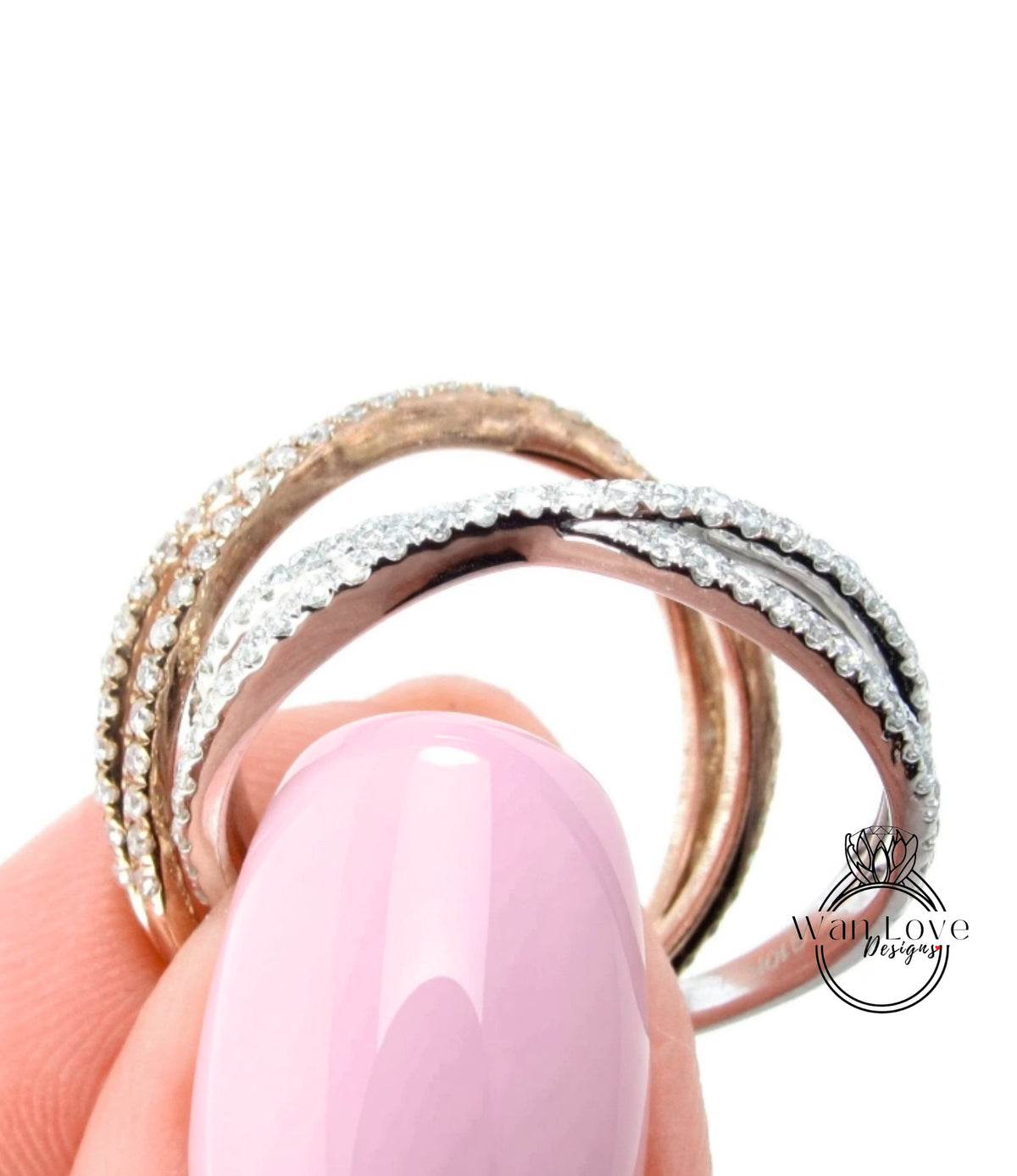 A close-up of a person's hand holding a ring with multiple layers of rings, with a pink nail polish on the finger.