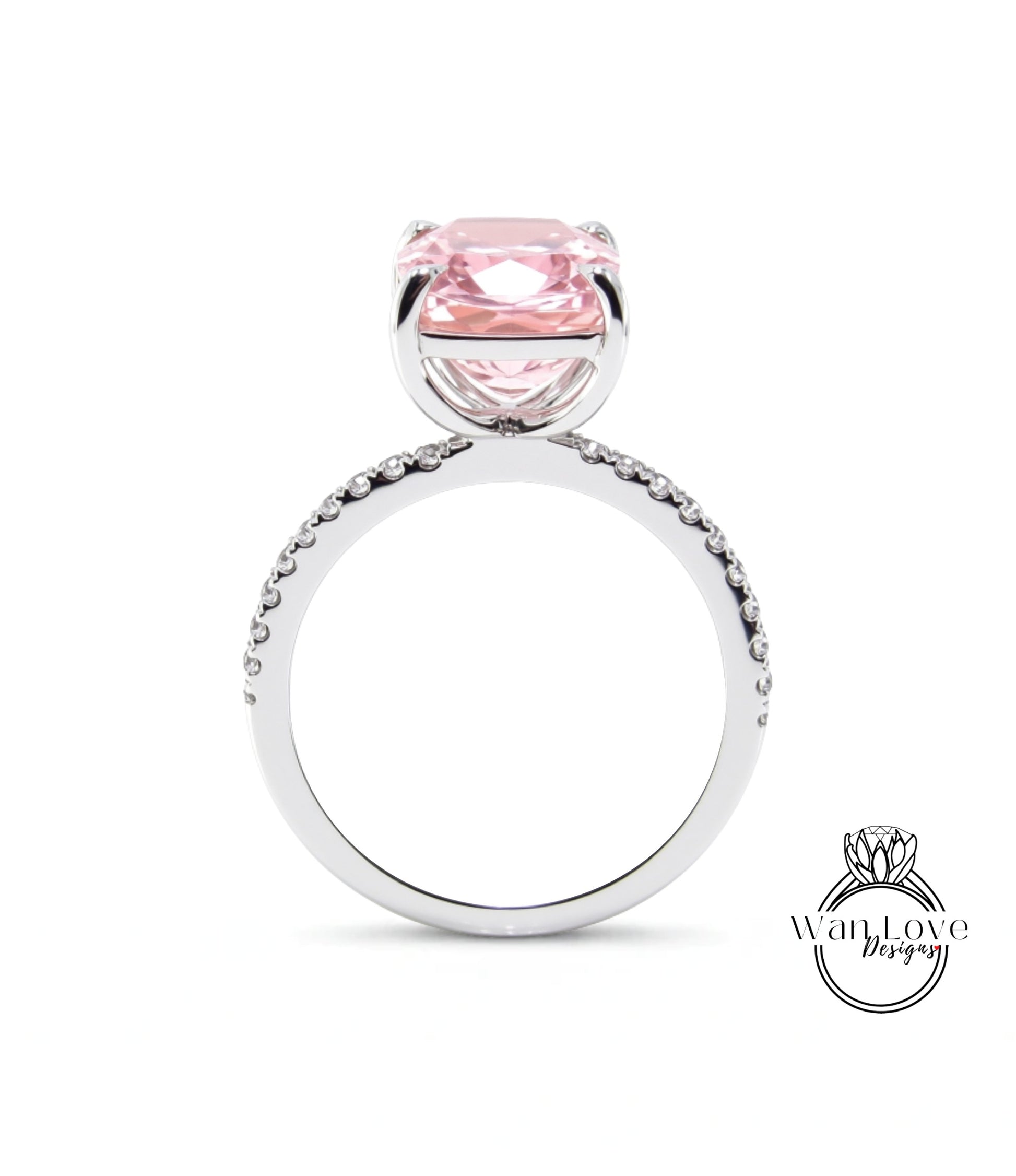 A silver ring with a large pink gemstone, likely a diamond, set in the center.