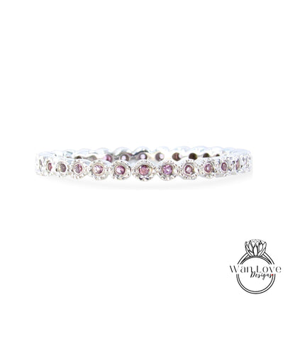 A silver band with a row of small, round, purple gemstones set in it.