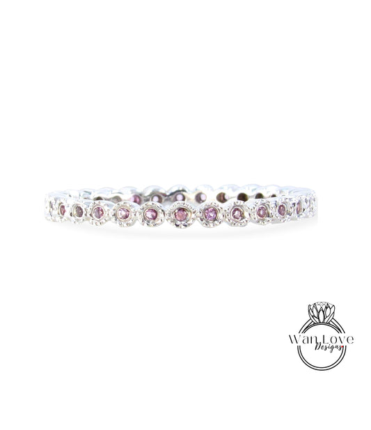 A silver band with a row of small, round, purple gemstones set in it.