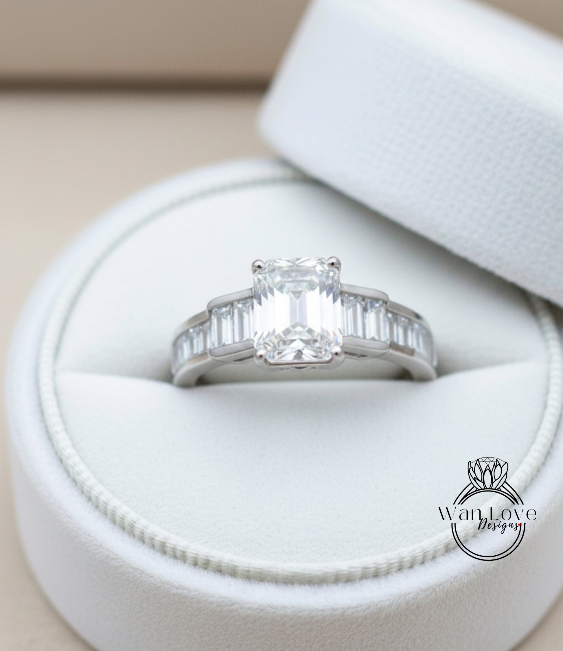 A diamond engagement ring is displayed in a white jewelry box, showcasing its intricate design and sparkling clarity.