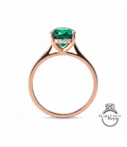 A rose gold engagement ring with a large, vibrant green gemstone set in the center.