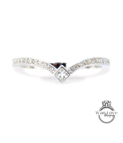 A silver ring with a diamond-encrusted band and a central square-shaped diamond.