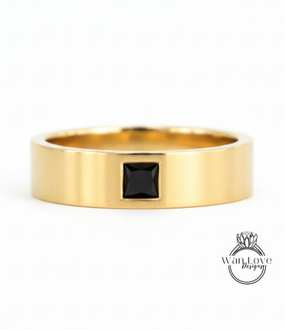A gold ring with a black gemstone in the center.
