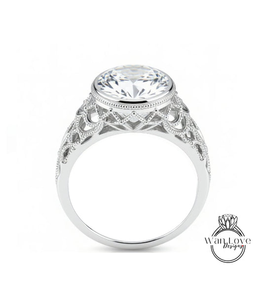 A close-up of a silver ring with a large, round diamond at the center, showcasing the intricate design and craftsmanship of the piece.