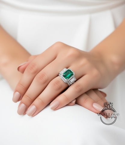 A close-up of a person's hand wearing a large, ornate ring with a green gemstone.