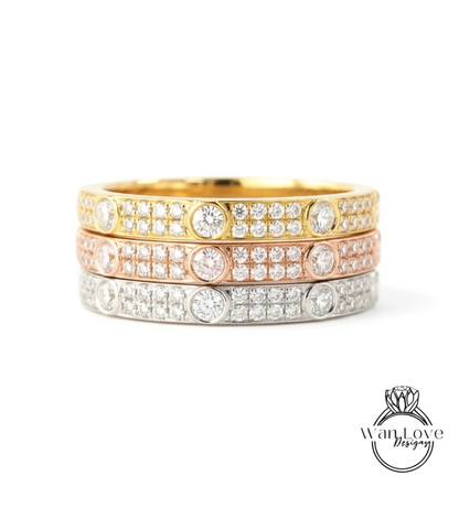 A stack of three rings with diamonds set in various colors, including gold, silver, and pink.