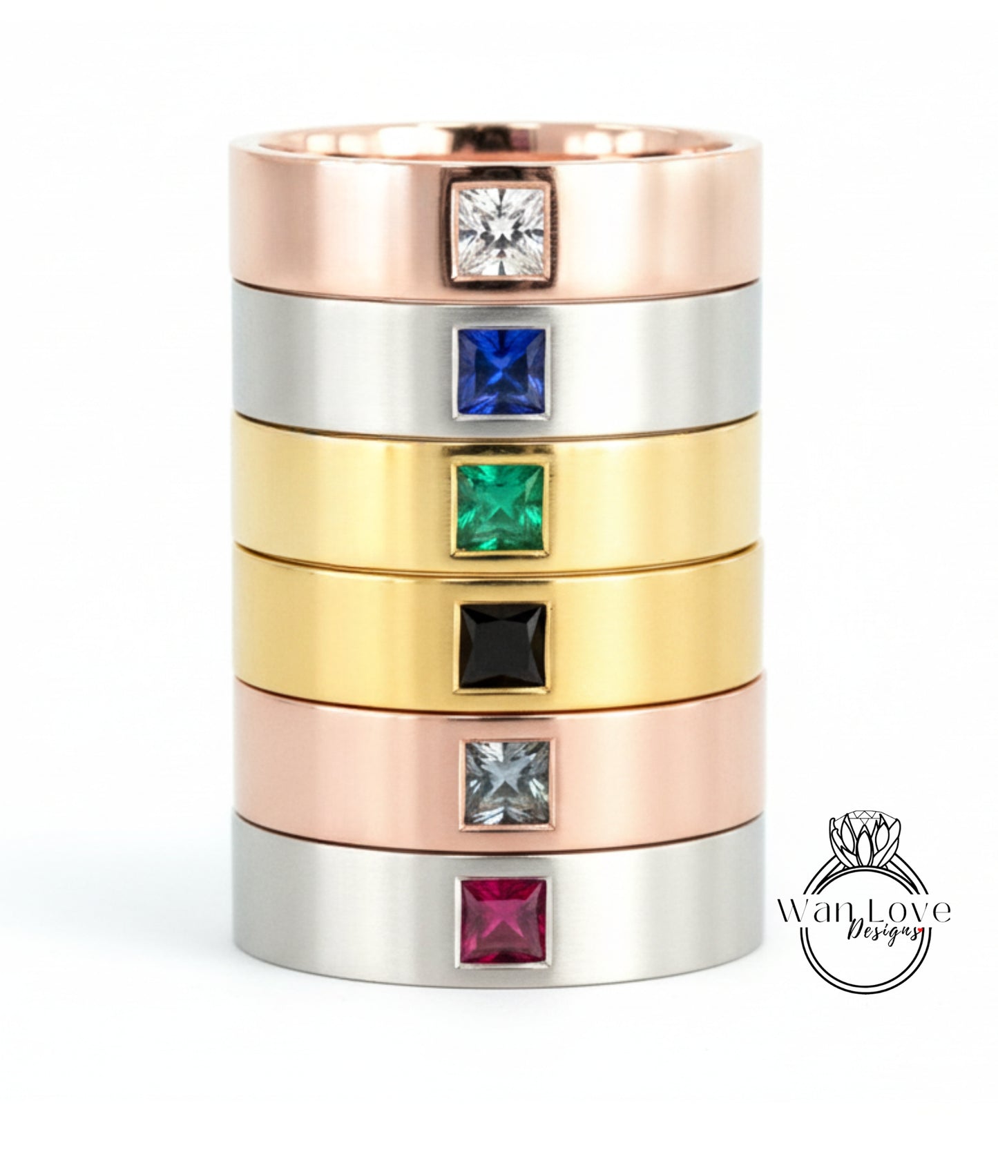 A stack of rings with various colored gemstones set in the center, including a ring with a large diamond and smaller diamonds in different colors.