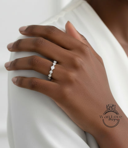 A close-up of a person's hand wearing a diamond ring on the ring finger.