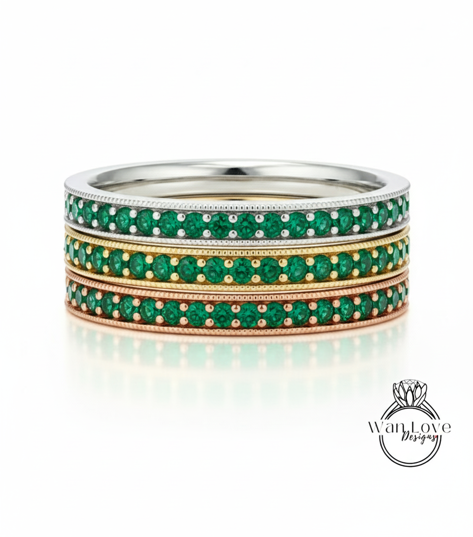 A stack of three rings with green gemstones set in a metallic band.