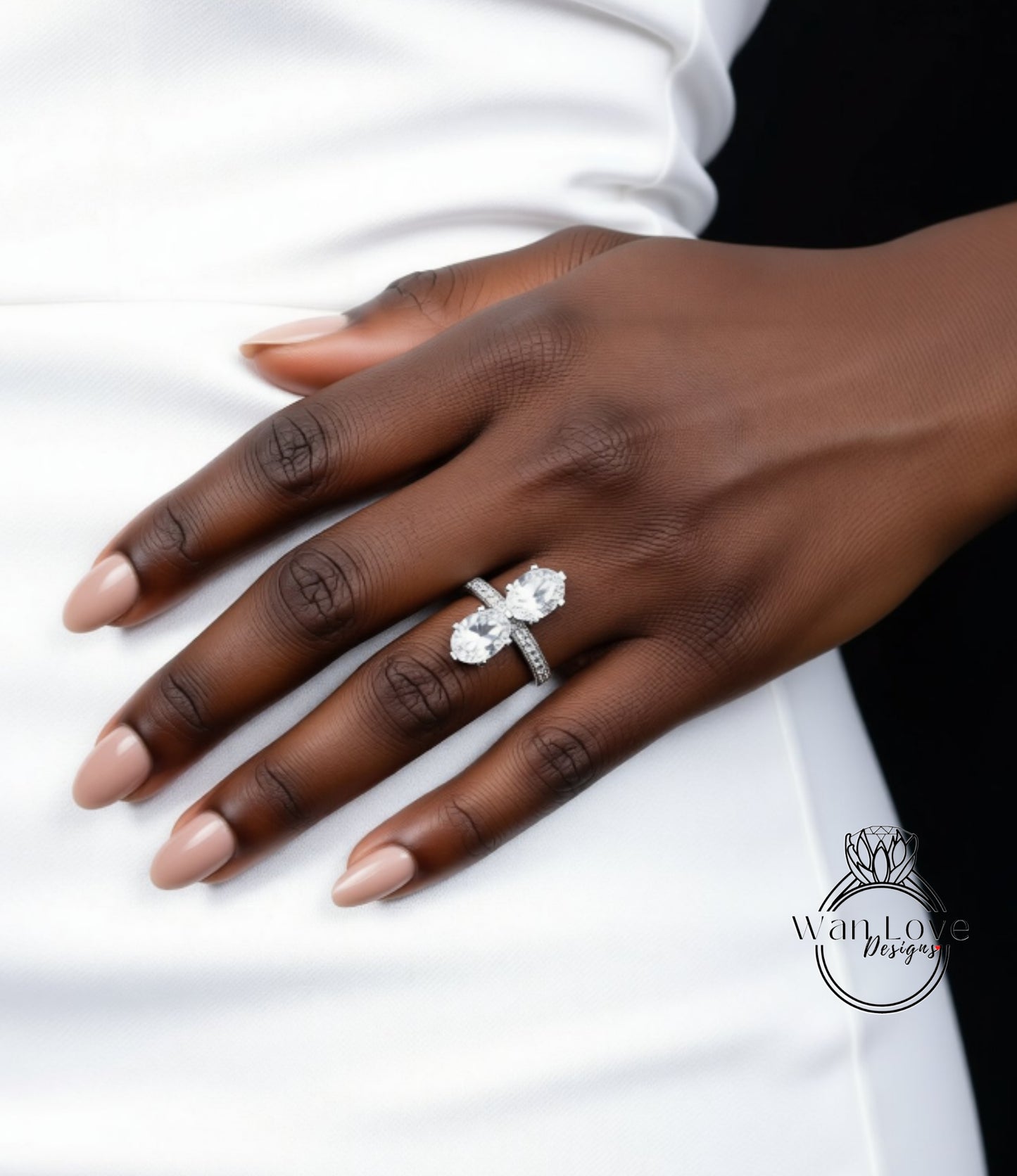 A close-up of a person's hand wearing a large diamond engagement ring.