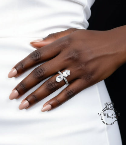 A close-up of a person's hand wearing a large diamond engagement ring.