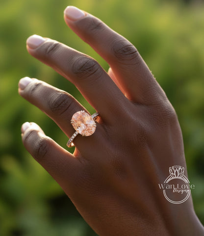 A close-up of a person's hand wearing a large, oval-shaped diamond engagement ring with a bezel.