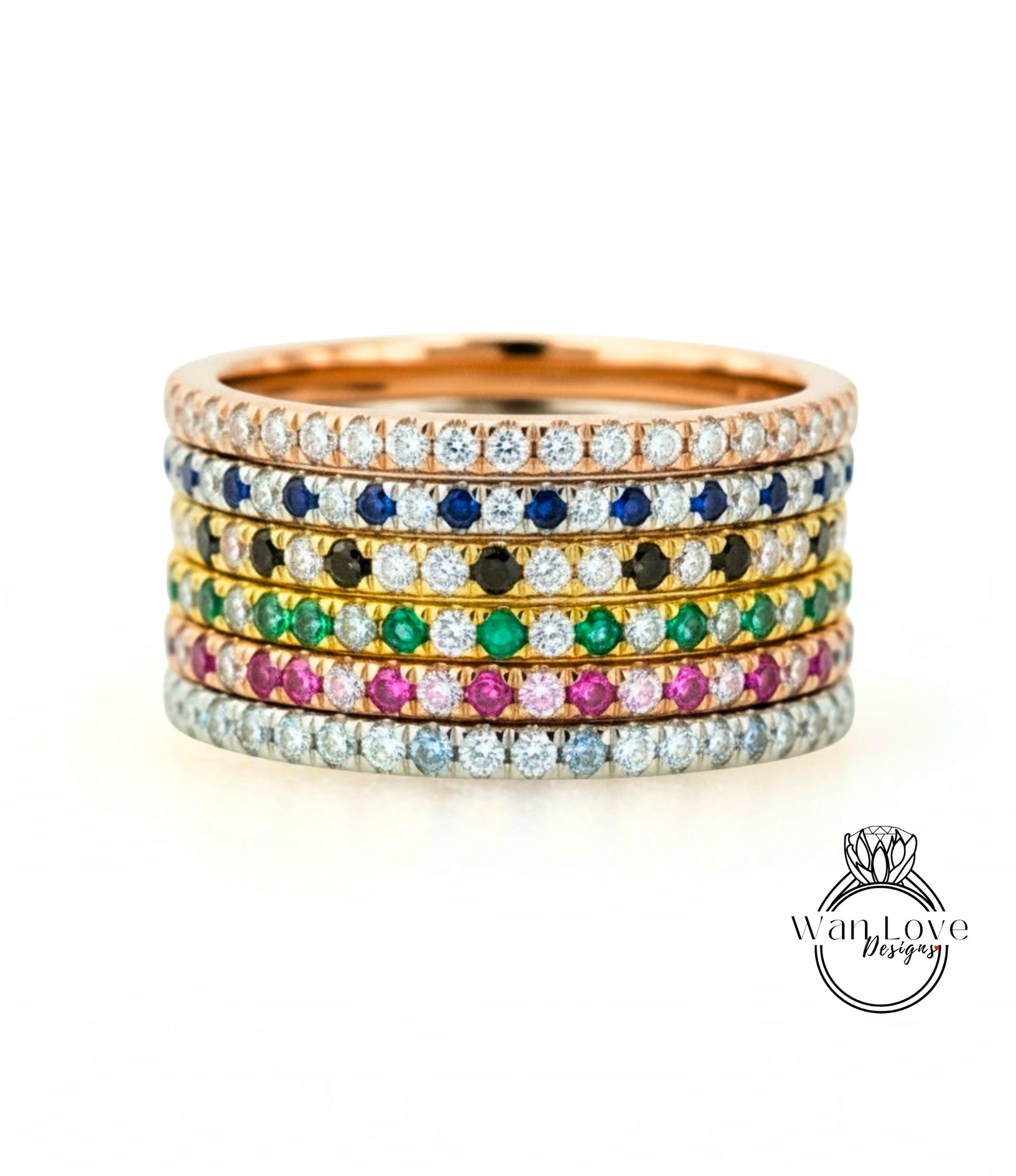 A stack of rings with various colored gemstones set in a gold band.