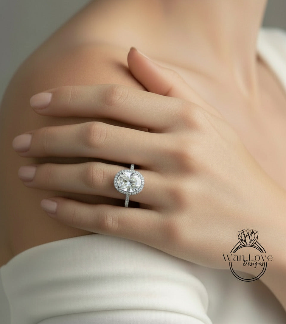 A close-up of a person's hand wearing a large, sparkling diamond ring on the ring finger.