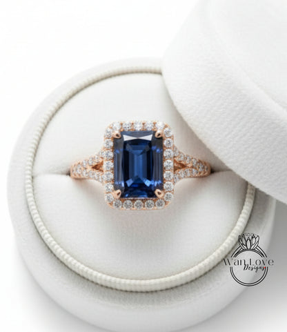 A beautiful blue gemstone ring with a halo of diamonds, displayed in a white jewelry box.