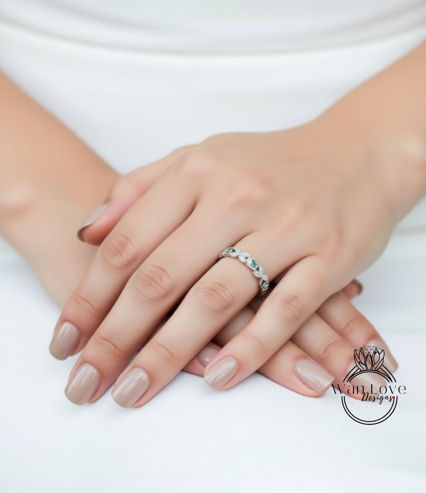 A close-up image of a person's hands wearing a ring with a floral design.