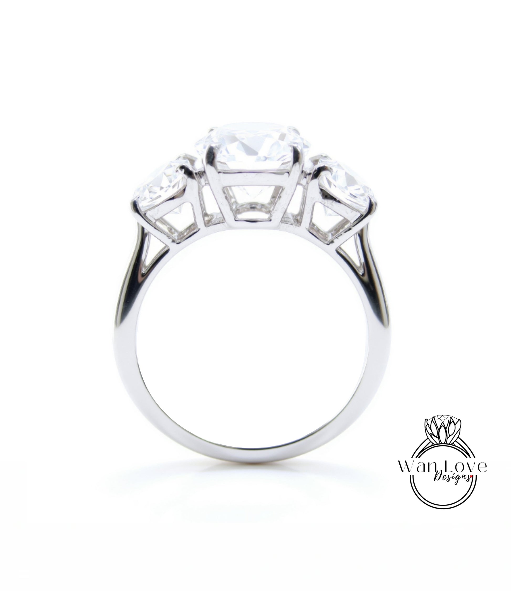 A silver engagement ring with a large central diamond surrounded by smaller diamonds on either side.