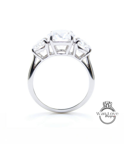 A silver engagement ring with a large central diamond surrounded by smaller diamonds on either side.