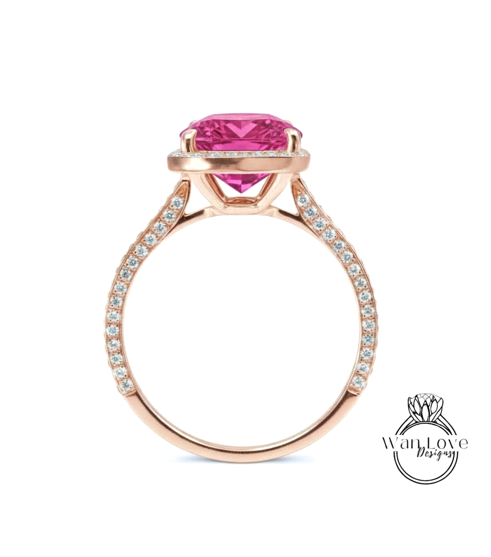 A rose gold engagement ring with a large pink gemstone set in the center, surrounded by smaller diamonds.