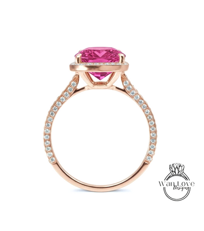 A rose gold engagement ring with a large pink gemstone set in the center, surrounded by smaller diamonds.