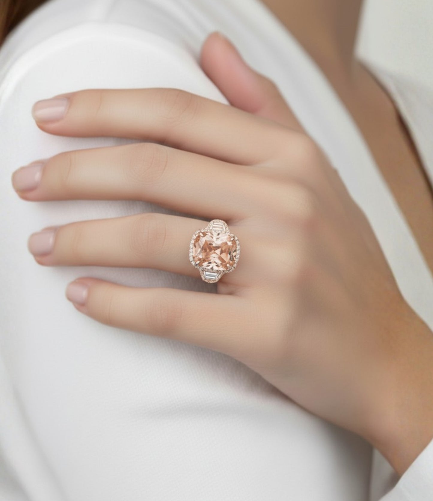 A close-up of a person's hand wearing a large, ornate ring with a large, round, pink gemstone.
