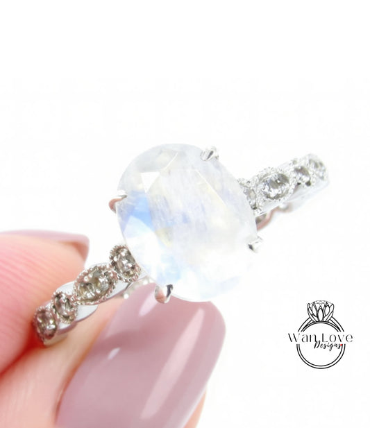 A close-up of a person's hand holding a diamond engagement ring with a large oval-shaped gemstone.
